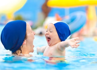 happy child mom swimming pool cap fun hug at sea